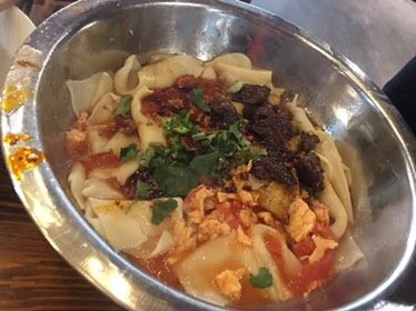 裤带面,将番茄炒蛋浇在面条上，加入适量的肉干葱花拌匀