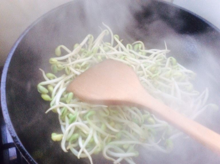合菜饼,油热下豆芽翻炒片刻放醋翻炒均匀(豆芽下热锅容易出水,放醋就能防出水,出水容易把饼泡软),