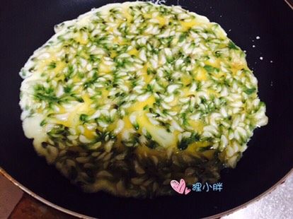 槐花蛋饼,锅内入适量的油,下入一半槐花蛋液,拿着锅把手转一圈。让蛋液铺均匀,两面煎熟即可出锅