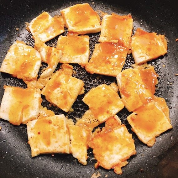 韩式香煎豆腐,将涂抹过酱料的豆腐翻面小火煎,在背面继续涂抹酱料