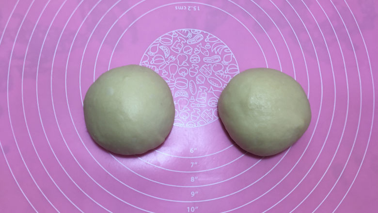 美味的牛排披萨,取出披萨面团,排气后平均分割成两份并揉圆。