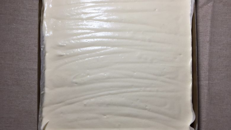 可可漩涡蛋糕,将蛋糕糊倒进铺有油纸的烤盘中,震出大气泡,用两根牙签不规则划动,划出小气泡,随后再轻震几下