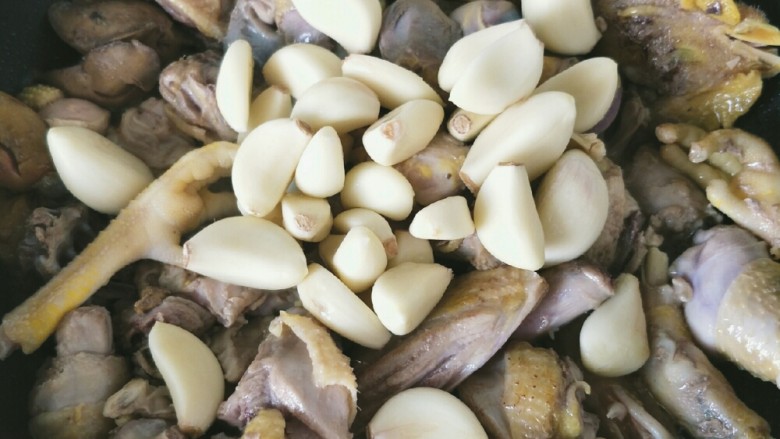 红烧小公鸡(家的味道),翻炒小公鸡没有血色后加入蒜子,翻炒一小会。