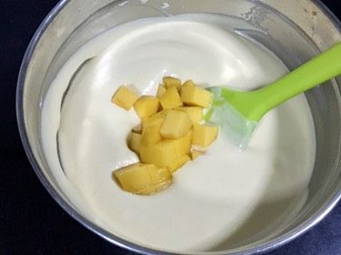 芒果慕斯鲜花蛋糕,再把80克一份的芒果丁加入搅拌均匀的慕斯液里,再次搅拌均匀。