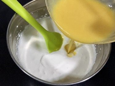 芒果慕斯鲜花蛋糕,把芒果泥倒入打发好的淡奶油盆里,搅拌均匀。