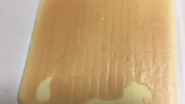 手绘母亲节蛋糕,上面盖一张油纸,把蛋糕卷再倒扣过来,就是正面朝上。