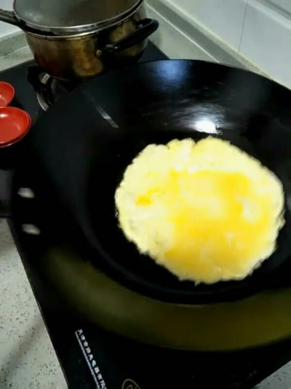 家常炒面,均匀旋转炒勺,把鸡蛋煎制成饼状。盖在炒面上。