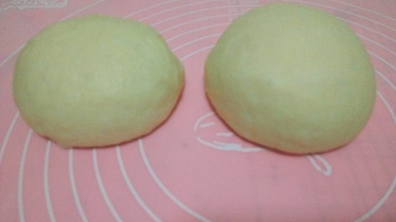 酸奶软欧,按压排气,分成两份,盖保鲜膜松驰15分钟;