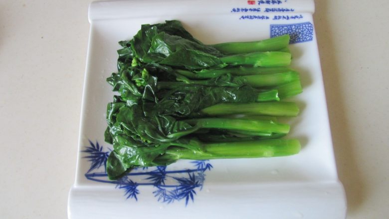 虾仁扒芥蓝,芥蓝变色后微微焯一分钟,将它捞出后控干水分摆放在盘中;