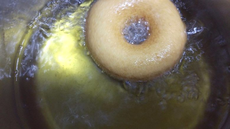 小黄人巧克力甜甜圈,热锅热油,烧到150度左右,小心地将二次发酵好的面包圈放入油中炸,中途翻面。我用的小油锅,耗油少,但是只能两个一起炸。