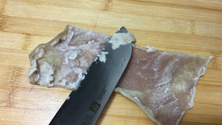 自制肉皮冻,5分钟后将肉皮取出,趁热再用刀清理一下没有弄干净的肥肉。