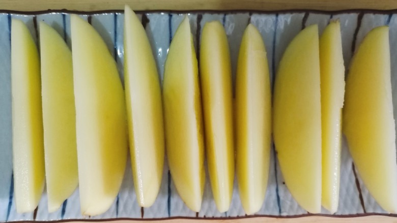 怪味儿烤薯角,先把土豆对半剖开,再切成这种月牙形。