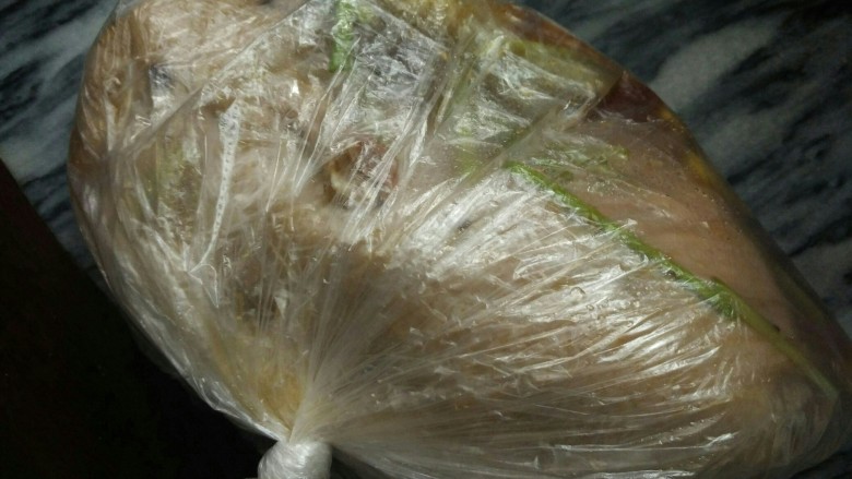 蜜汁烤全鸭,把鸭放进保鲜袋,倒入调料,打好结,稍微转一下,让调料在保鲜袋里分布得更均匀,放入冰箱冷藏室腌制一晚上