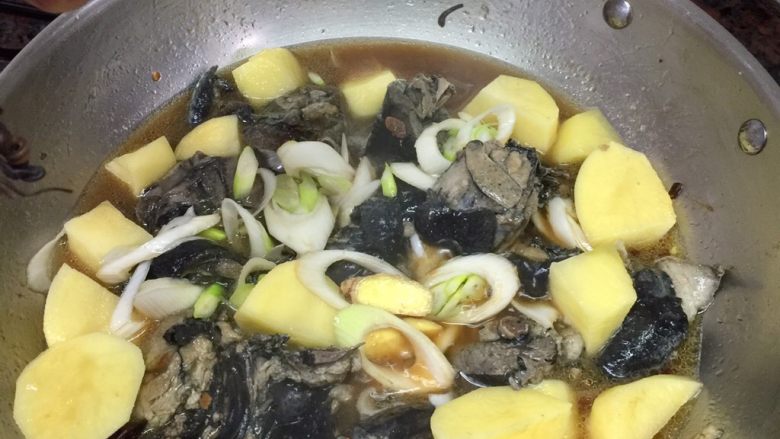 啤酒乌鸡,洒一小撮盐,干拌均匀,盖上锅盖,转中火焖煮