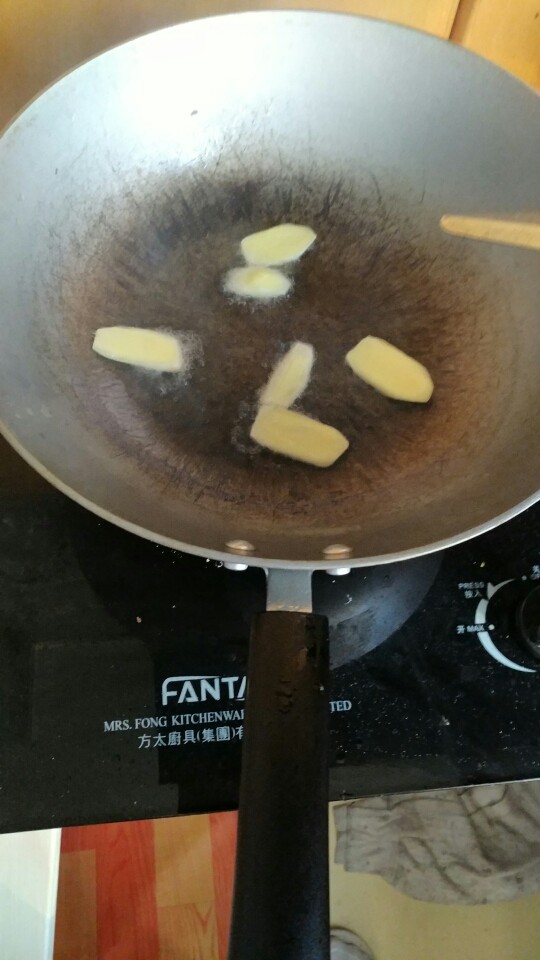 新手之可乐鸡翅,锅热起来,倒入油,把姜片放进去炸一下,油会香些,还可以去去腥