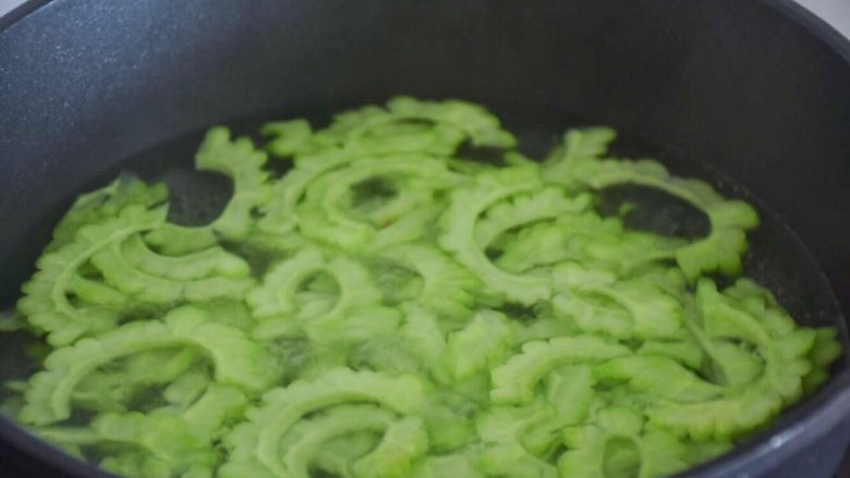 凉拌苦瓜,盐渍好的苦瓜用水冲洗,锅里水烧开,苦瓜放进去煮沸。喜欢口感脆的煮沸就好,喜欢口感软一点的可以多煮几分钟。