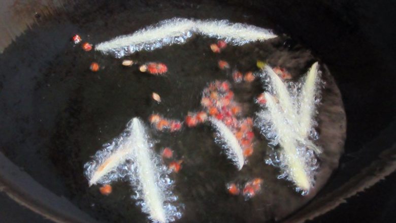 韭香螺蛳肉,热锅注入油5分热,下入姜丝、花椒炸出香味,捞出弃之