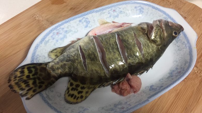 清蒸鳜鱼,鱼刮鳞,开肚,去腮,内脏清洗干净,控干水份,两面鱼身划几刀。