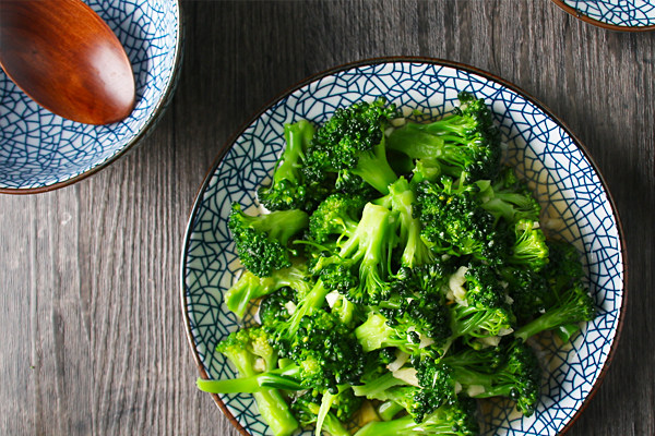 清爽西兰花#美食拔草大作战#,捞出后倒入冷水中冷却,拌上蒜蓉和调料装盘就可以了