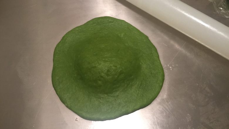 黄桃奶酪抹茶包,取一小块,擀成中间厚边缘薄的圆片,小刀对切4刀,留中间凸起处不切断
