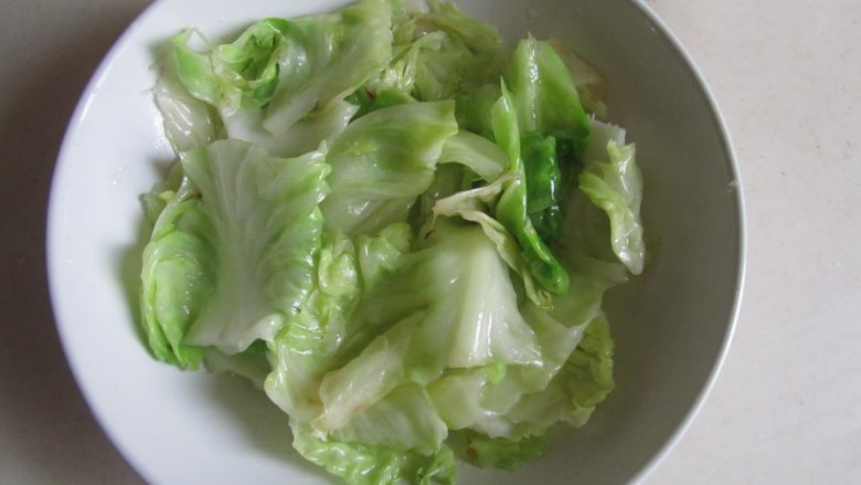 金汤龙利鱼,将炒过的包菜叶片垫入碗中;
