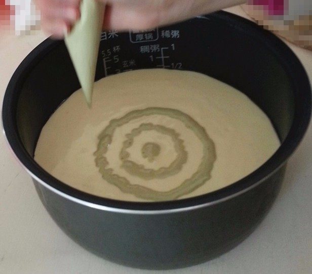 电饭煲版~抹茶拉花蛋糕,用拌好的抹茶糊,在蛋糕糊表面画圆