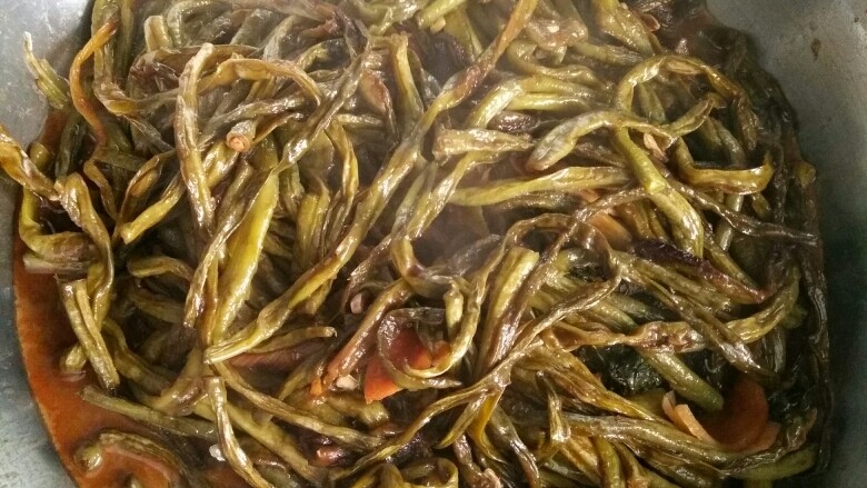 家常酱豇豆,为了受热、入味均匀和避免糊锅,要用筷子翻动几次。