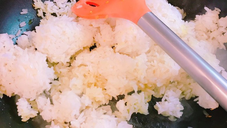 小企鹅家什锦黄金炒饭,在锅中倒入大量油,加入米饭,大火翻炒,尽量让每一粒米饭都有油。