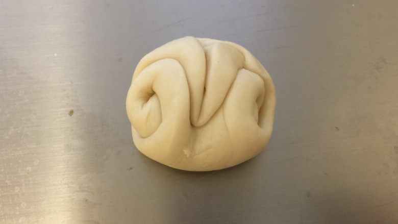美味肉松酥,将刚才的卷卷收口朝上,用筷子在中间压一下,把两头往中间并拢。
