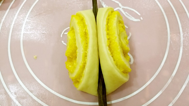 椰蓉花卷面包,取一个小面卷,用筷子在中间轻压一下。