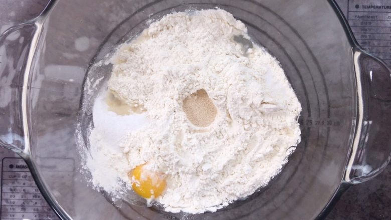 咸蛋黄肉松麻薯面包,启动厨师机揉面,待面团揉至脱离内桶缸壁并形成团,即达到初步扩展阶段,加入<a style='color:red;display:inline-block;' href='/shicai/ 887'><a style='color:red;display:inline-block;' href='/shicai/ 887'>黄油</a></a>。