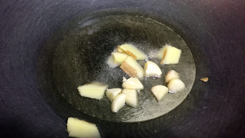红烧鸡翅,锅里倒入少许油,六七成热,放入姜蒜炒香;