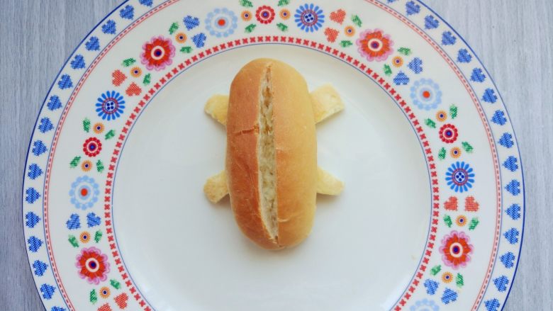 小热狗造型面包,在上部的中间切一条开口，不要切透，留出放<a style='color:red;display:inline-block;' href='/shicai/ 425'>香肠</a>和<a style='color:red;display:inline-block;' href='/shicai/ 92833'>生菜叶</a>的空间即可