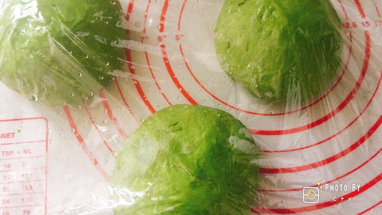 超级松软的荔枝抹茶软欧包,取出面团排气,分成三等份,分别揉成团,盖上保鲜膜松弛一刻钟。