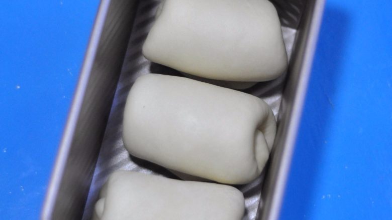 鸡肉杂蔬土司盒,第二次擀卷后,将面团放入土司盒中。