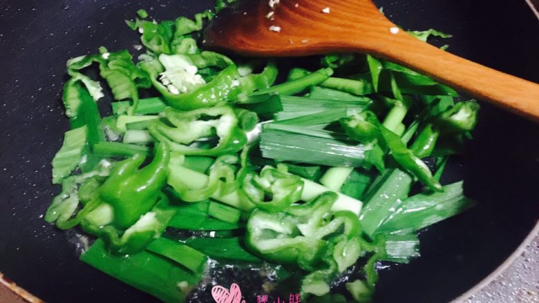青椒炒猪肝,锅内入适量油,加入蒜苗和青椒段翻炒