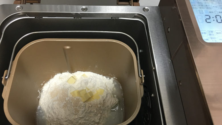杏仁片小面包,将主面团材料一起放入面包机内,启动面包机标准面包程序进行揉面。