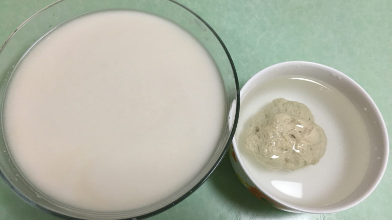 自制凉皮(洗面版),这时留下来的面团就是面筋,洗出来的面水就是做凉皮的糊。将面筋放入盛满水的碗中同面水一起放入冰箱静置一夜。