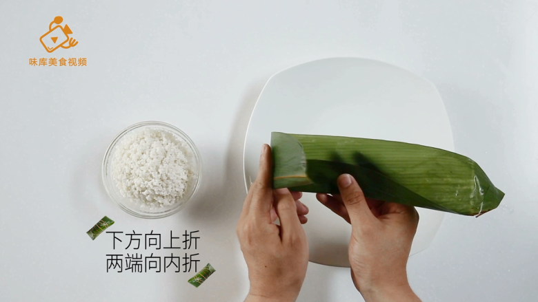 4种最实用的包粽子方法,一学就会,将一张<a style='color:red;display:inline-block;' href='/shicai/ 211314'>粽叶</a>,下方向上折,两端向内折