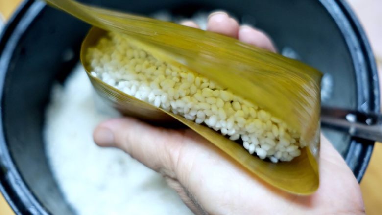 蜜枣白米甜粽,剩下2/3的粽叶往上折叠,盖住糯米。