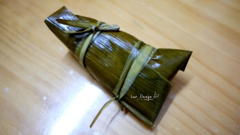 蜜枣白米甜粽,取两根棕榈叶包扎紧。
棉纱线的话就直接从上往下缠绕就可以了。
