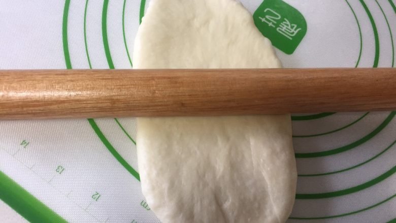 烫种牛奶吐司,取出一个松弛好的面团擀开,擀成牛舌状。
