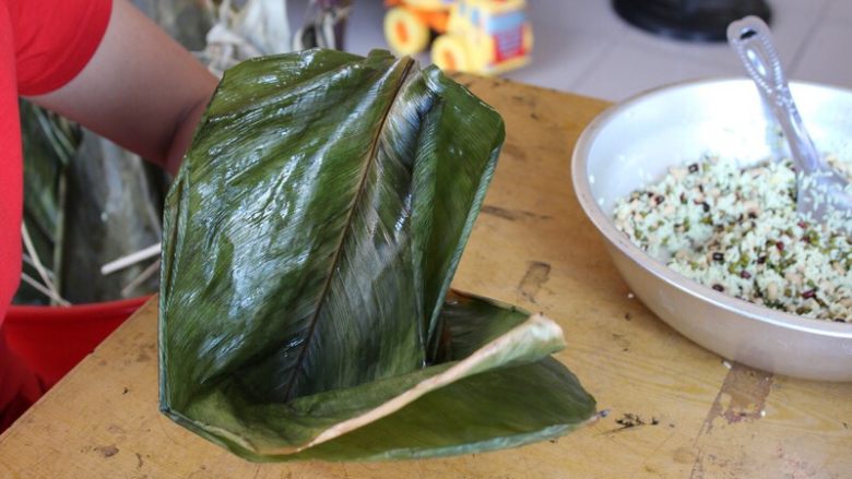 广式香菇花肉粽子（超详细，两种办法）,（三角形粽子）从中间开始折出一个漏斗型，左手托着，粽叶短的那边向着自己