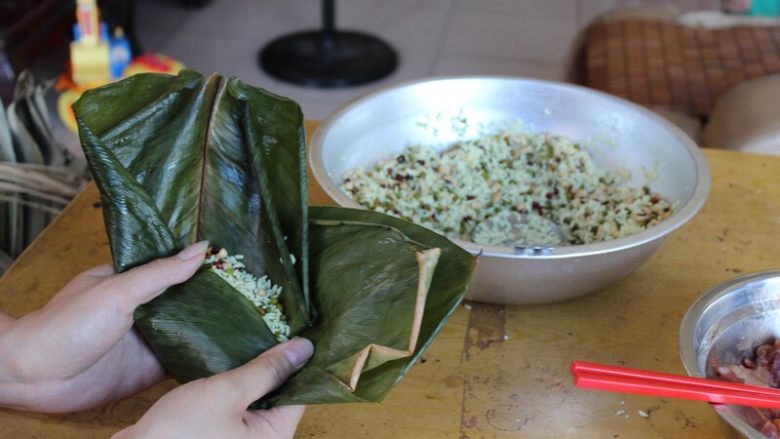 广式香菇花肉粽子（超详细，两种办法）,（三角形粽子）从靠近身体的那边粽叶开始叠，往中间叠