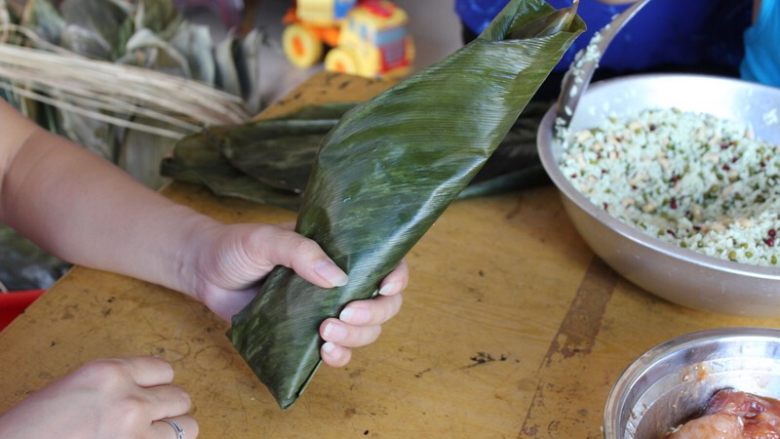 广式香菇花肉粽子（超详细，两种办法）,（长形粽子）然后把粽子掉个头，没折好的一头向上，向下抖抖，使内馅往下沉