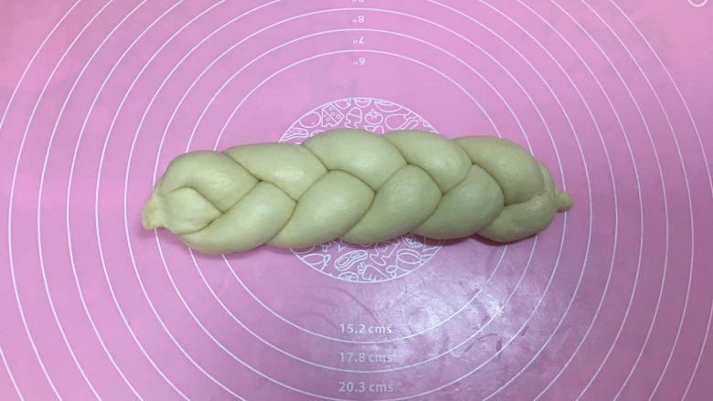 淡奶油辫子面包,然后将辫子翻转过来,开始编左侧,收口处同样捏紧。