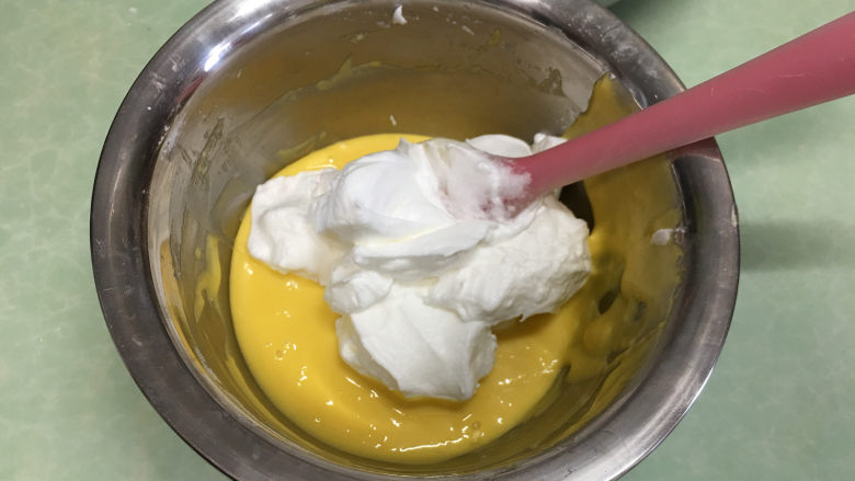 8寸原味戚风蛋糕,取1/3蛋白霜放入蛋黄糊中。(这时打开烤箱进行预热,温度为上管110度,下管150)