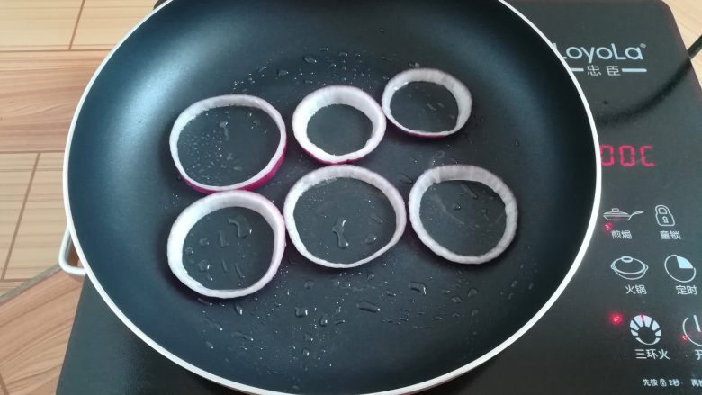 洋葱蔬米饼,不粘锅里刷一点点油,放入洋葱圈小火加热