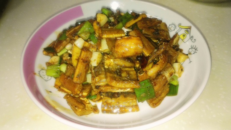 烧小鲨鱼干,待锅中水快干时,加入蒜瓣、葱、鸡精,装盘起锅