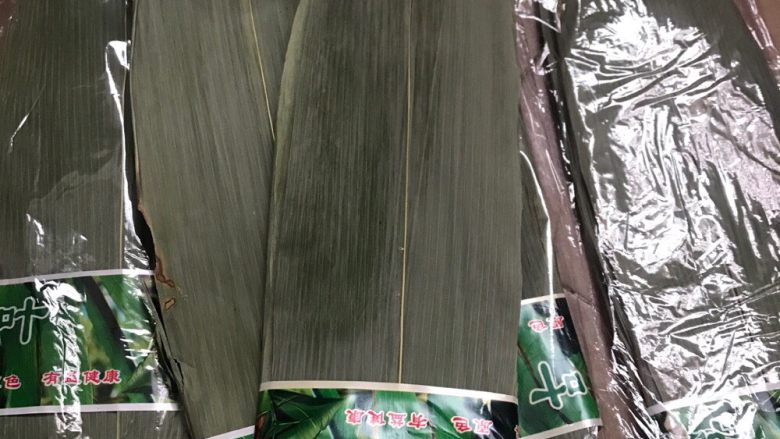 端午佳节包粽子,将买回来的粽叶用清水浸泡三至4小时,然后起锅大火烧水烧开,将粽叶放下去煮三至5分钟,由于粽叶比较大,煮的过程中可以用筷子搅动,但是千万要注意,不要将粽叶弄烂了,不然到时候就不好包了,最后放清水一片一片洗干净待用。